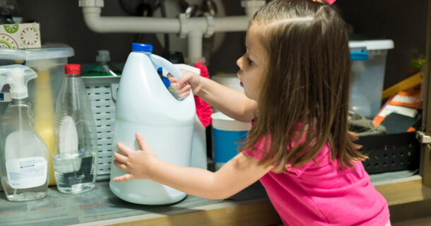 Young child grabbing chemical container