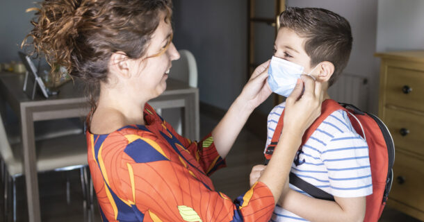 Mother adjusting mask on boy